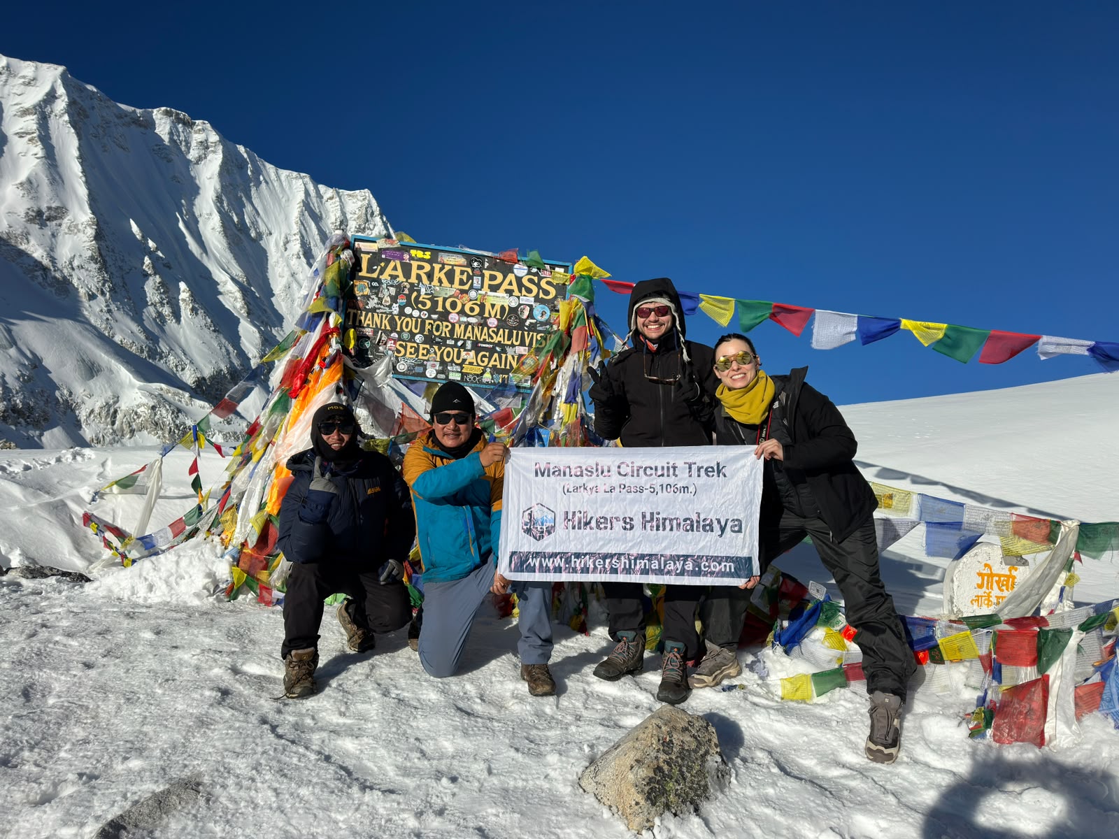 Trekkers celebrating at Larkya La Pass (5,106m) during the Manaslu Circuit Trek in Nepal.
