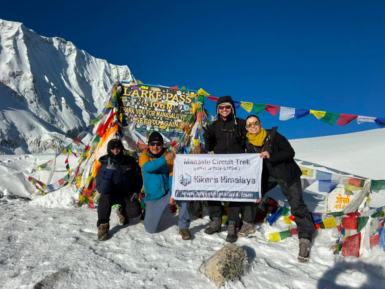 Trekkers celebrating at Larkya La Pass (5,106m) during the Manaslu Circuit Trek in Nepal.