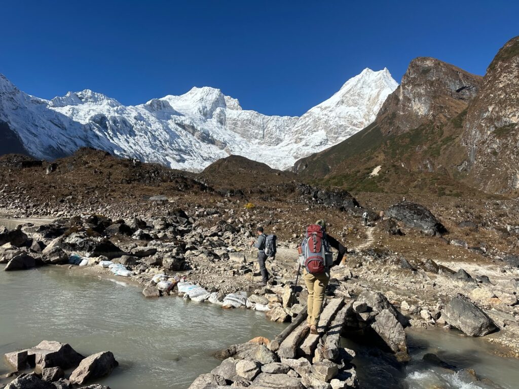 Trekkers crossing a stream on the Manaslu Circuit Trek